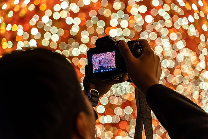Fotograaf neemt foto van lichtjes met hoop bokeh