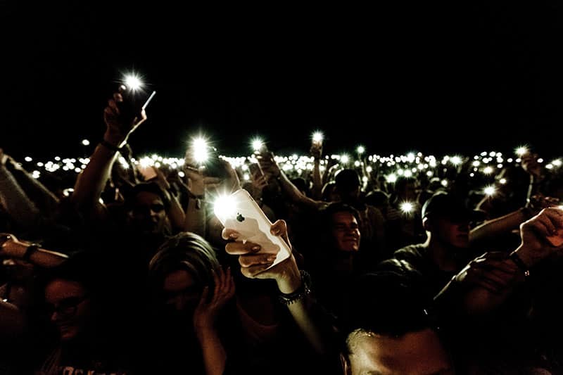 Handen met mobiele telefoons en flitslichten aan